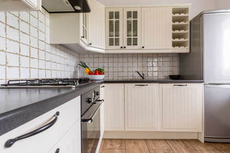 Light kitchen with white wooden furniture and solid worktop