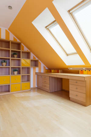 Shot of a spacious room with a big desk and orange wallsの写真素材