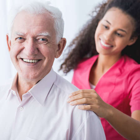 Picture of happy positive senior and afroamerican caregiverの写真素材