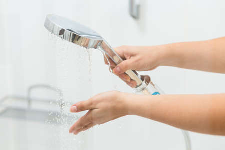 Cropped picture of a woman holding a showerheadの写真素材