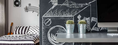 Corner of a room with the desk and computer at the blackboard wall backgroundの写真素材