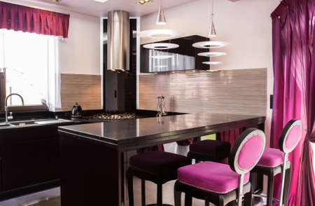 Photo of dark open kitchen with tableの写真素材