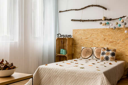 Light bedroom with double bed, DIY wooden furniture and creative decorationsの写真素材