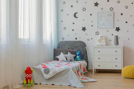Light child bedroom with single bed and star wall decor