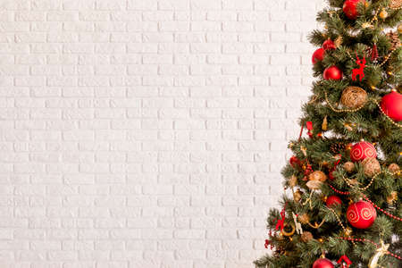 Traditional Christmas tree on a white brick wall backgroundの写真素材