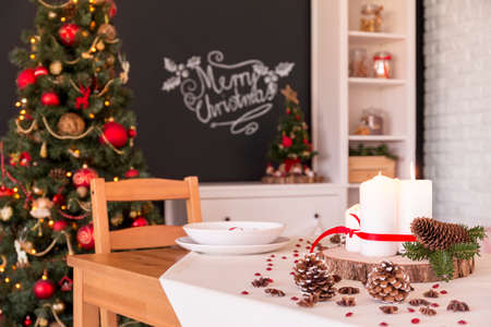 Modern flat with traditional Christmas dinner table decorationの写真素材