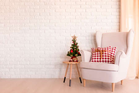 Simple Christmas living room with armchair and small Christmas treeの写真素材