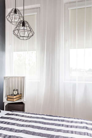 Shot of big windows in a modern black and white bedroom