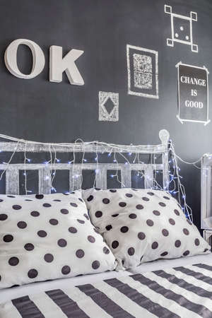 Shot of a decorated blackboard wall and a bed in a black and white bedroomの写真素材