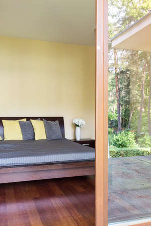 Bedroom with the marital bed with cushions and the patio entry