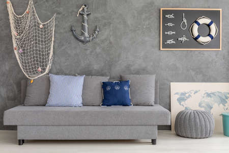 New design grey home interior with nautical decorations, sofa and small poufの写真素材
