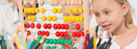 Close-up of children using abacus during math lessonの写真素材