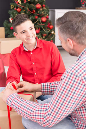 Happy father and son packing christmas gift boxの写真素材