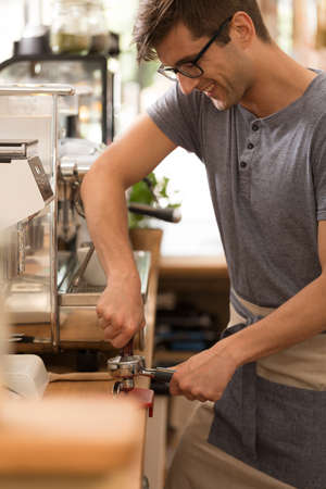 Shot of a young man working as a barista in a cafeの写真素材