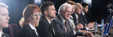 Competition between politician during political debate before election. Older confident man in suit...