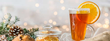 Close-up of hot tea with lemon in a glass on the christmas table