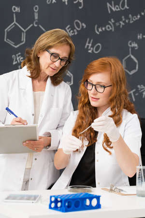 Shot of a chemistry professor checking her student's workの写真素材