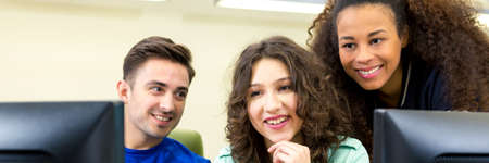 To girls and man having classes in computer room. Looking together on computer screen