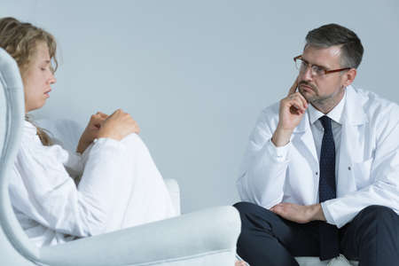 Anxious woman during meeting with a psychiatristの写真素材
