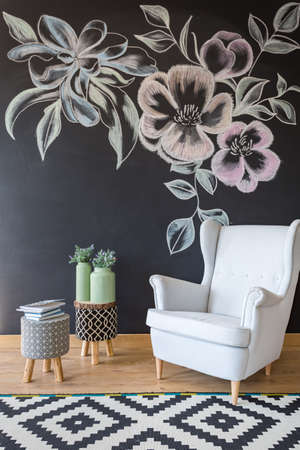 Room with white armchair, pattern carpet and chalkboardの写真素材