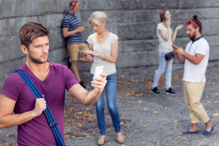 Group of tourists using their mobile phones outdoorsの写真素材