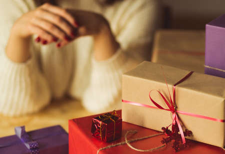 Young woman waiting for opening christmas presentsの写真素材