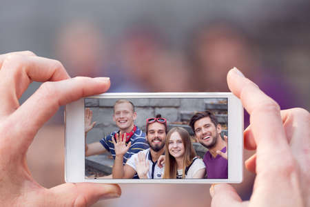 Phone picture of happy group of friendsの写真素材