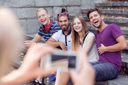 Person taking with phone picture of her friends