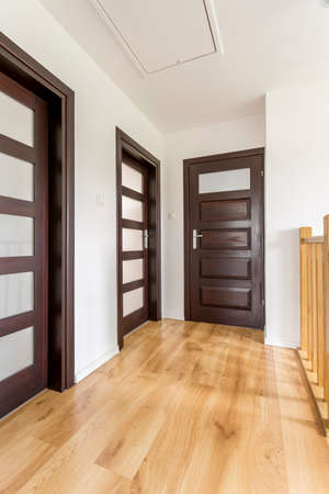 Shot of a corridor with three wooden doors
