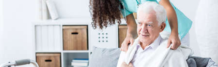 Young nurse is taking care of elder man 