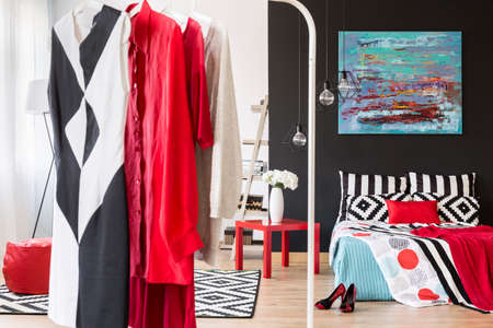 Formal woman's clothes hanging in a stylish bedroom