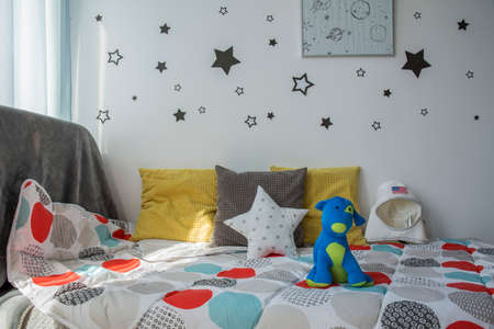 Comfortable small bed with toys in children's bedroomの写真素材
