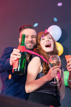 Man holding bottle of champagne and woman holding wine glassの写真素材