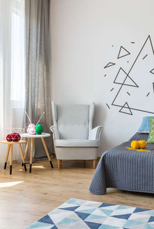 Corner of a bright bedroom with cosy armchair and coffee tablesの写真素材