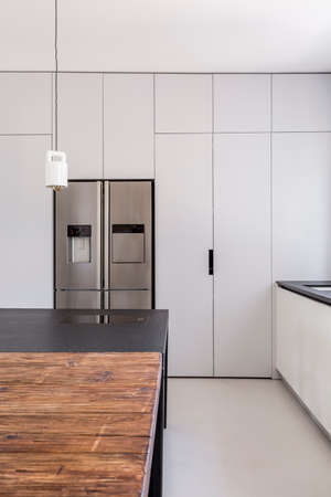 Simple functional kitchen with white walls and steel furniture