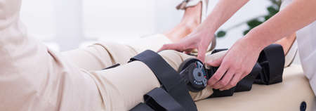 Closeup shot of a doctor's hands checking blood pressure from a woman's legの写真素材