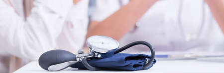 Closeup shot of a blood pressure monitor lying on a doctor's deskの写真素材