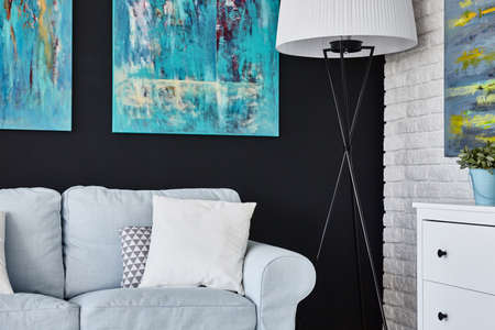 Comfortable living room with light furniture and blue paintingsの写真素材