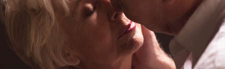 Panorama of elderly lovers kissing during intimate moments