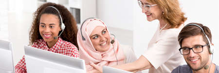 Teacher pointing at the computer to one of the participants of the language courseの写真素材