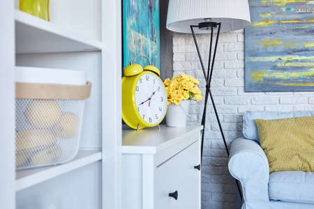Yellow alarm clock in cozy living roomの写真素材