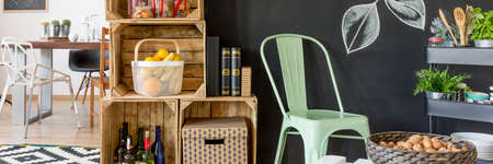 Cozy kitchen interior with wooden boxes, pastel chair and many accessoriesの写真素材
