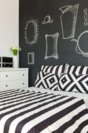 Big comfortable bed by the blackborad in modern bedroom