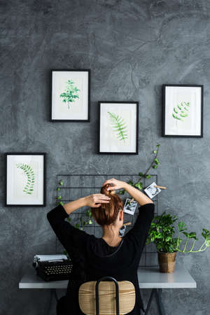 Woman working at the desk in plants apartment