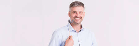 Bright panorama of a smiling mature man with a paper pipeの写真素材