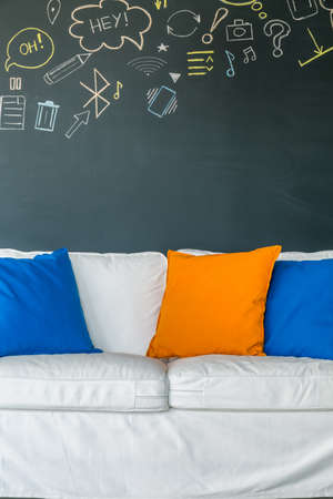 Room with white sofa with colorful pillows and chalkboard wallの写真素材