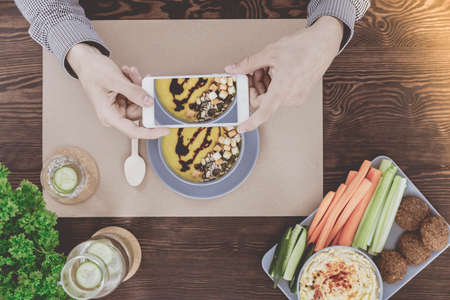 People taking picture of yellow cream soup