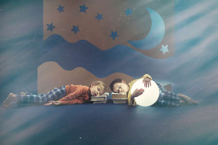 Tired young boys sleeping on booksの写真素材