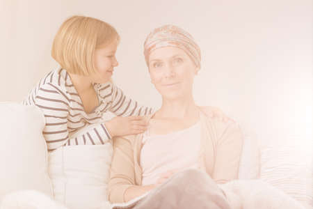 Small child supporting her ill mother during chemotherapyの写真素材