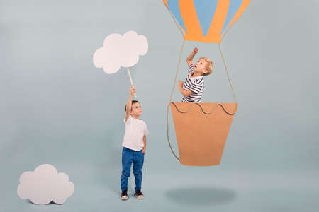 Boy in air balloon pointing the skyの写真素材